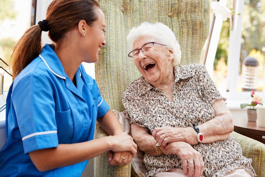 Smiling elderly woman laughing with a nurse