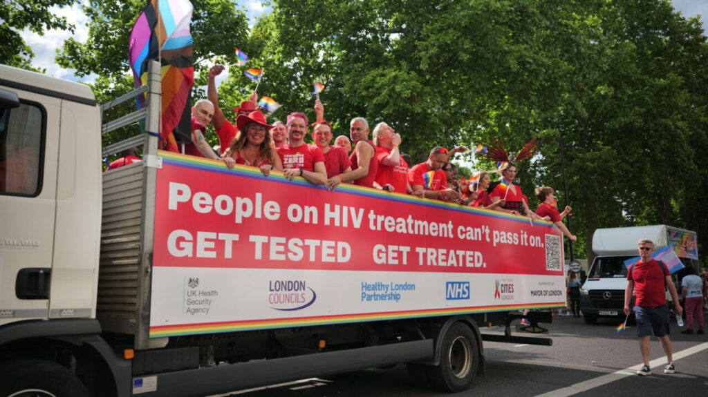 Fast Track Cities London at London Pride in 2023 on a truck with a sign on the side "People on HIV treatment can't pass it on. GET TESTED. GET TREATED.