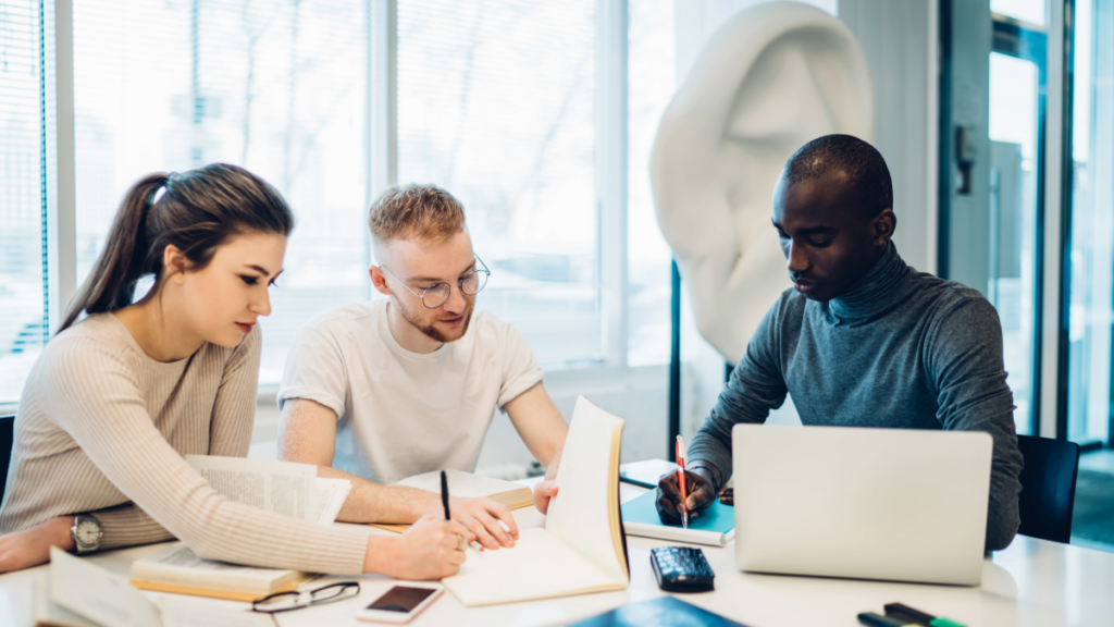 Two men and a woman working at a desk